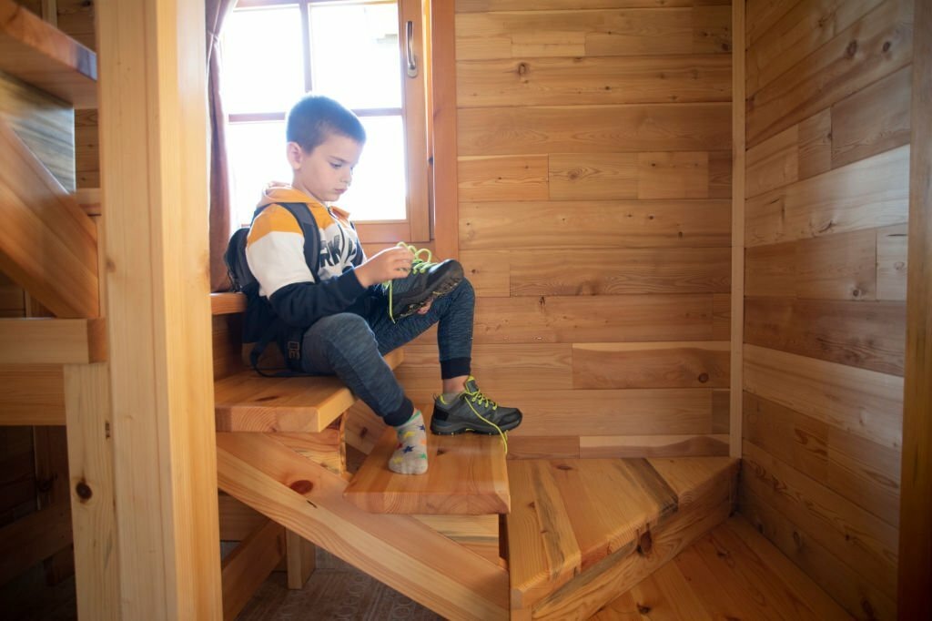 Boy sitting on finished wooden stairs